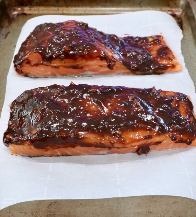 balsamic glazed salmon on a piece of parchment paper on a baking sheet