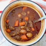 beef stew in a large pot with a serving spoon