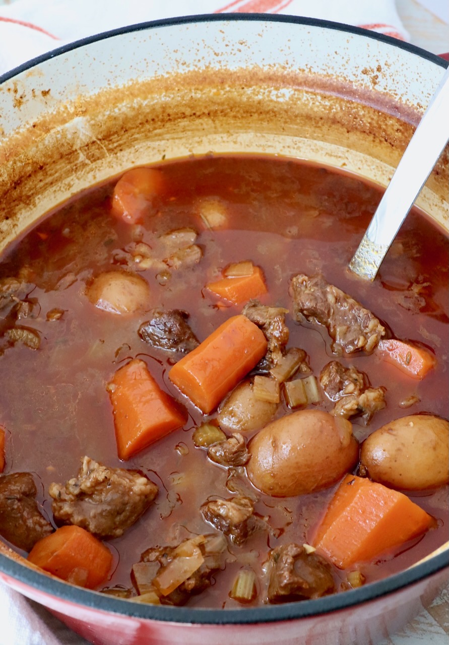 beef stew in pot with serving spoon