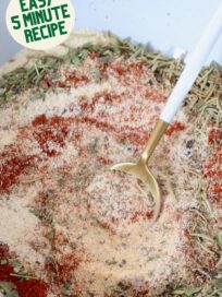 dried herbs and spices mixed together in a bowl with a spoon