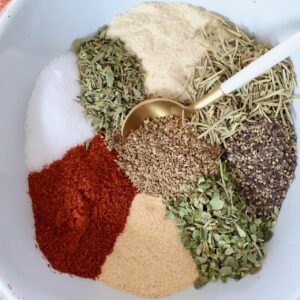 dried herbs and spices separated in a bowl with a spoon