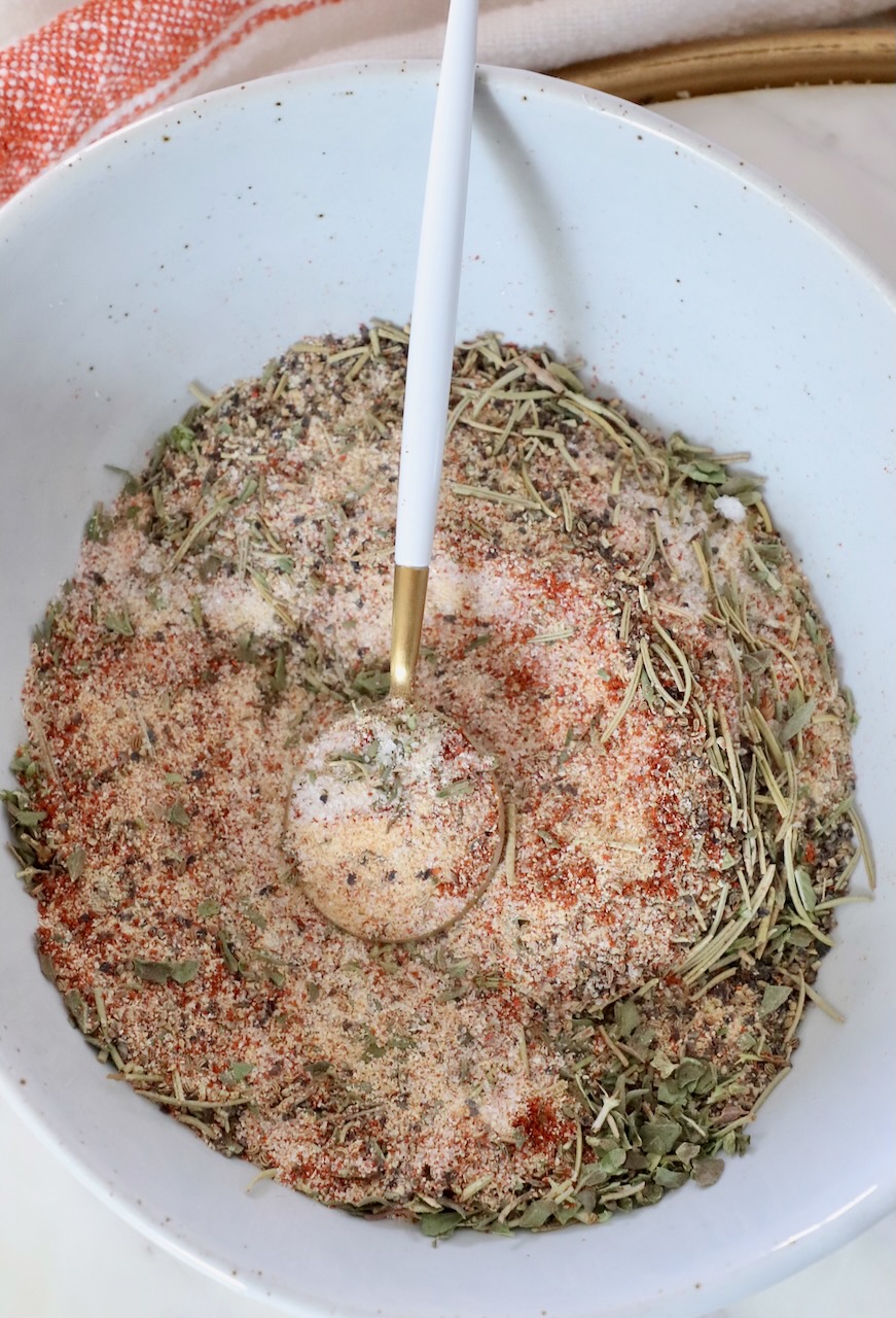 dried herbs and spices mixed together in a bowl with a spoon