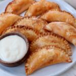 buffalo chicken bites on a plate with a small bowl of blue cheese dressing on the side