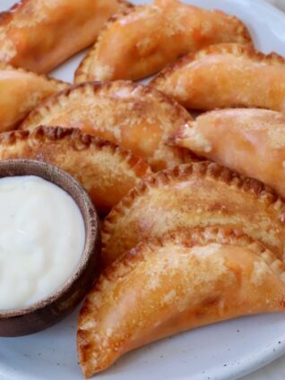 buffalo chicken bites on a plate with a small bowl of blue cheese dressing on the side