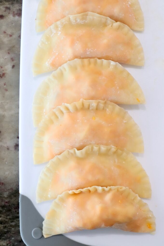 uncooked buffalo chicken bites lined up on a cutting board