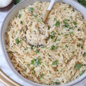 creamy orzo prepared in a bowl with a spoon