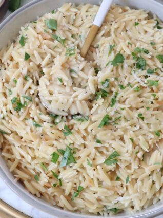 creamy orzo prepared in a bowl with a spoon