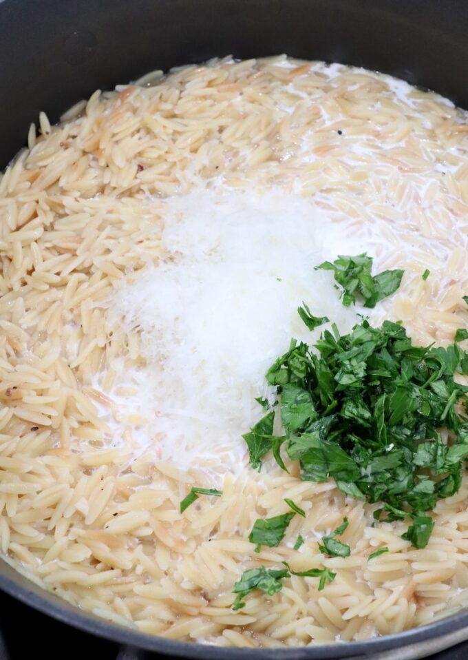 orzo pasta in a pot topped with parmesan cheese and parsley