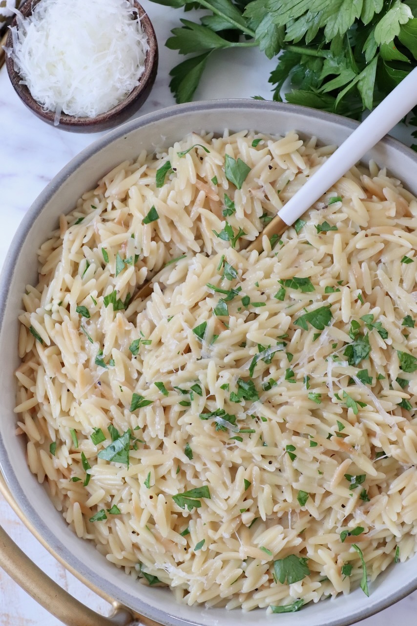 creamy orzo pasta in a bowl with a spoon