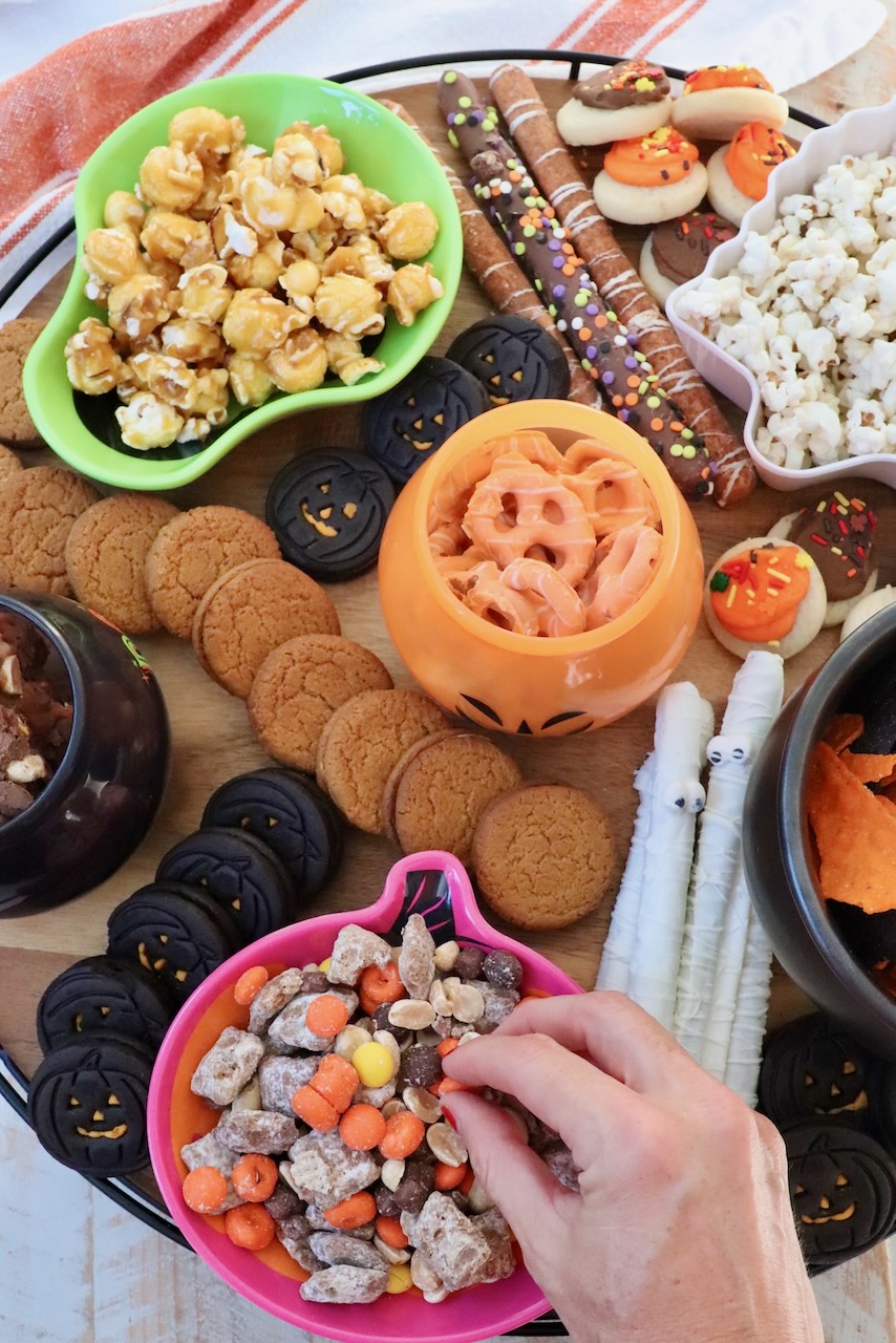 Halloween snack board with small bowls of snacks and cookies