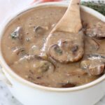 mushroom gravy in a bowl with a spoon