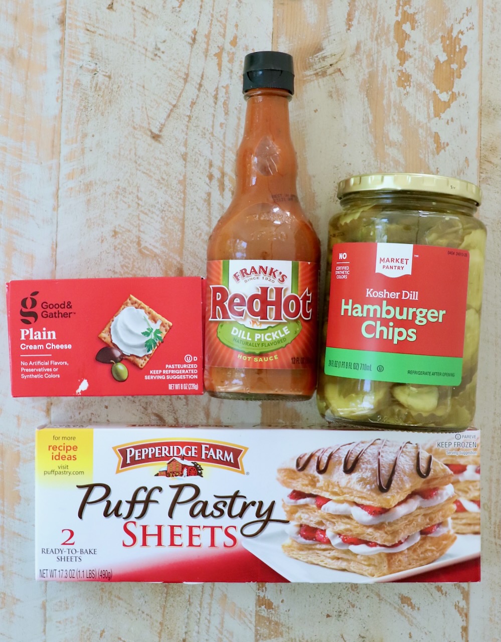 ingredients for puff pastry pickle bites on a white wood board