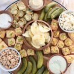 pickle board filled with dips, snacks and pickles