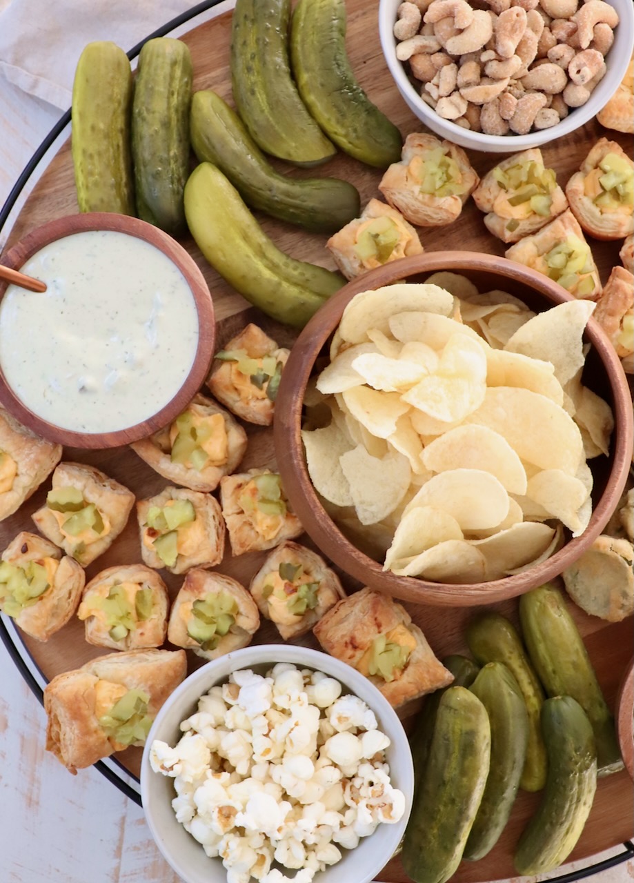 board filled with pickles and pickle-flavored chips, dips and popcorn