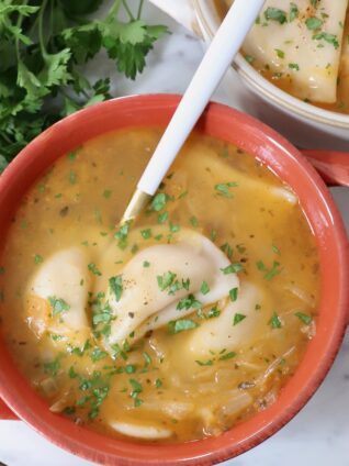 pierogi soup in bowl with a spoon