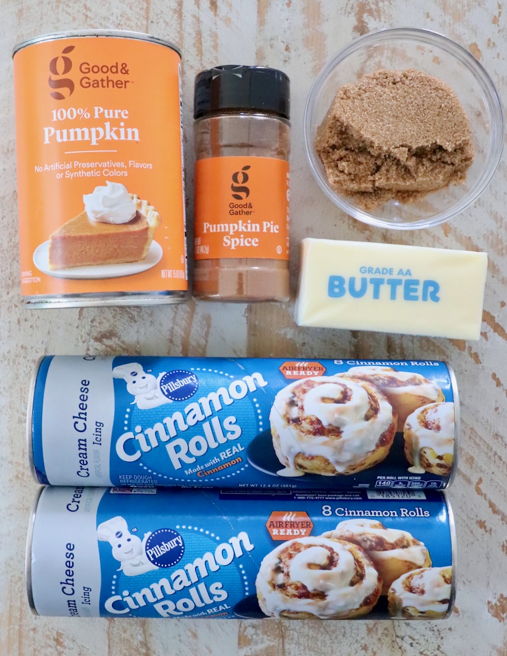 ingredients for pumpkin cinnamon rolls on a white wood board