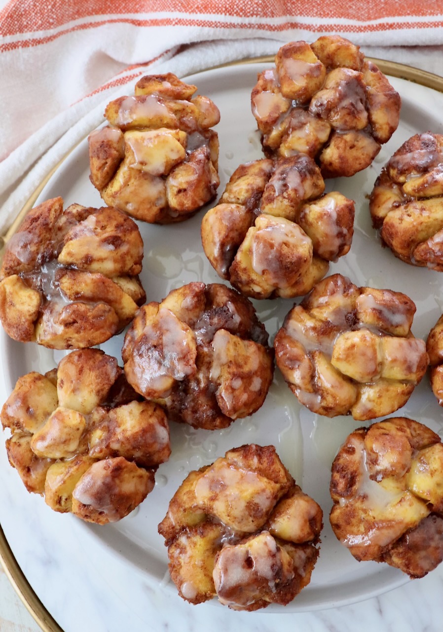 pull apart pumpkin cinnamon rolls on a plate drizzled with cream cheese icing