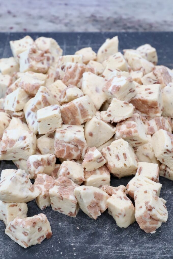 canned cinnamon rolls cut into small cubes on a cutting board