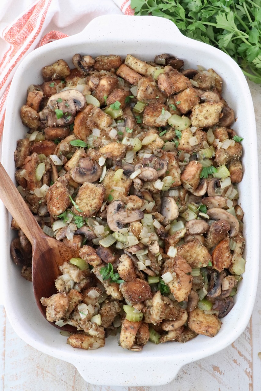 mushroom stuffing in a casserole dish with a serving spoon