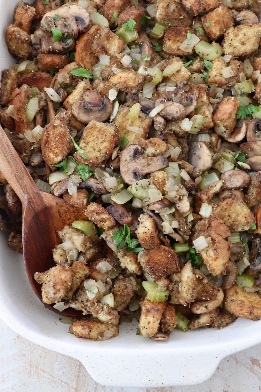 stuffing in a casserole dish with a serving spoon