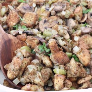 mushroom stuffing in a baking dish with a serving spoon