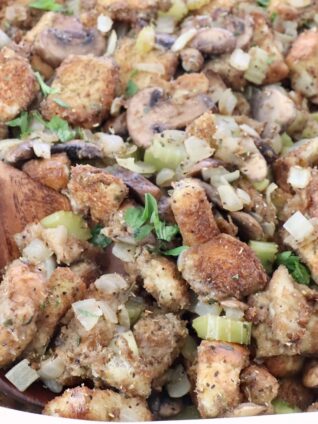 mushroom stuffing in a baking dish with a serving spoon