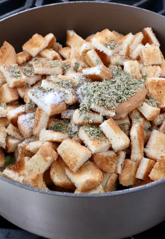 bread cubes in a large pot seasoned with spices and dried herbs