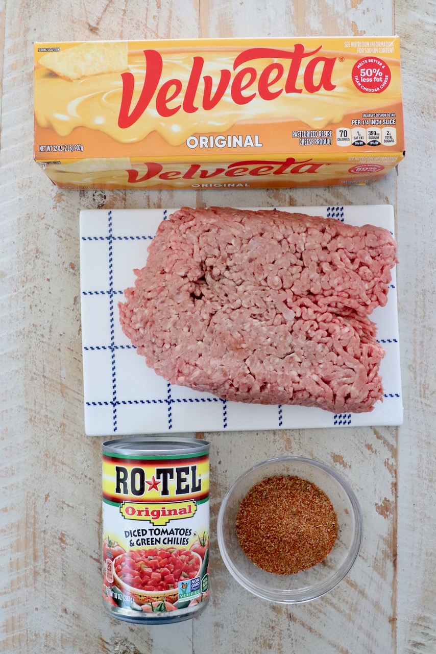 ingredients in rotel dip on a white wood board