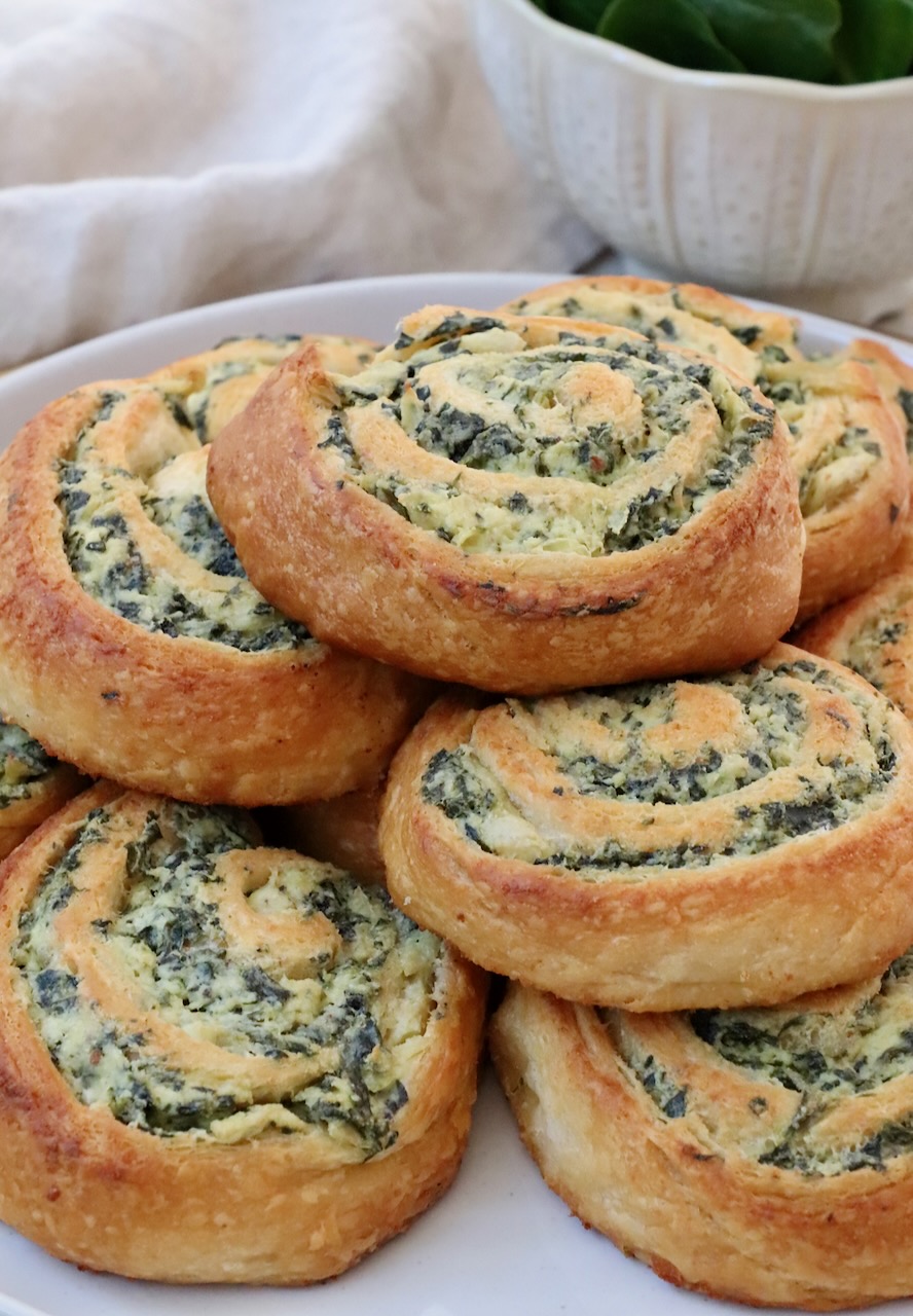 spinach rolls stacked up on a plate