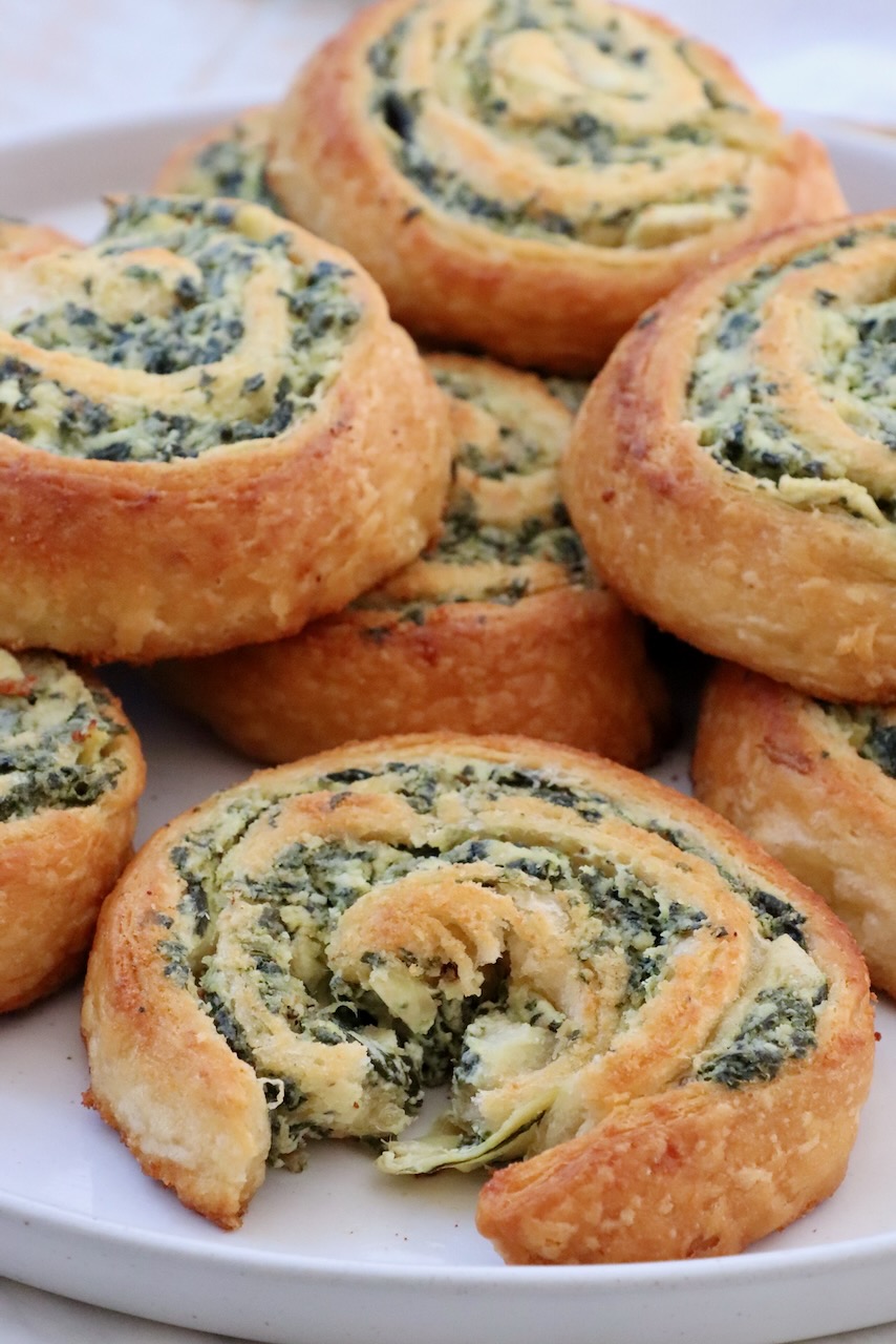 spinach dip rolls stacked up on a plate