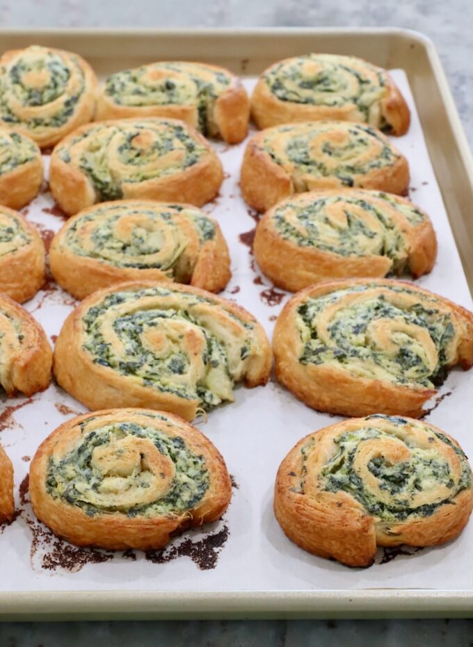 baked spinach pinwheels on a baking sheet