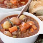 beef stew with potatoes and carrots in a bowl with a spoon