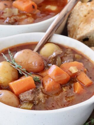 beef stew with potatoes and carrots in a bowl with a spoon