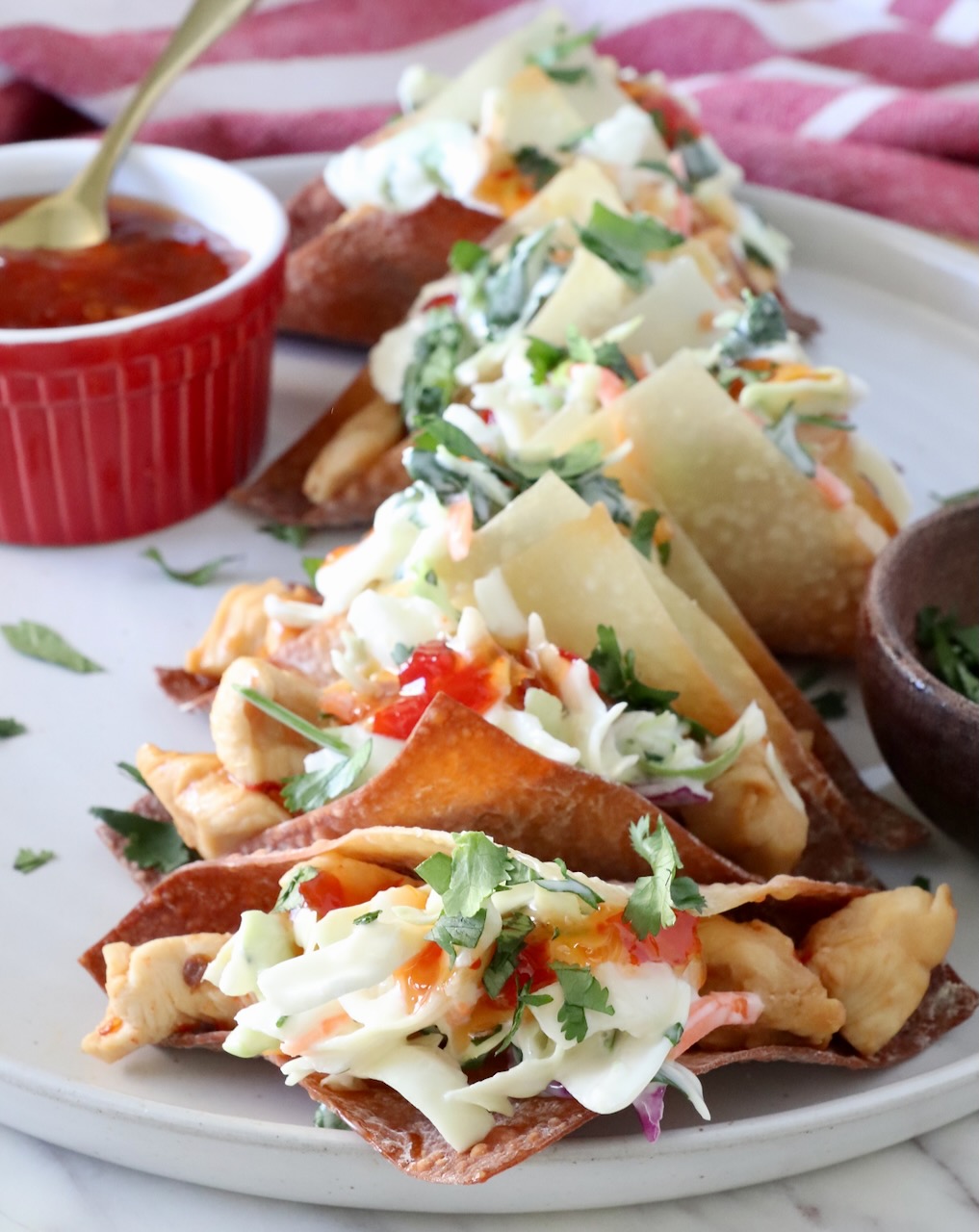 chicken wonton tacos topped with sweet chili sauce on a plate