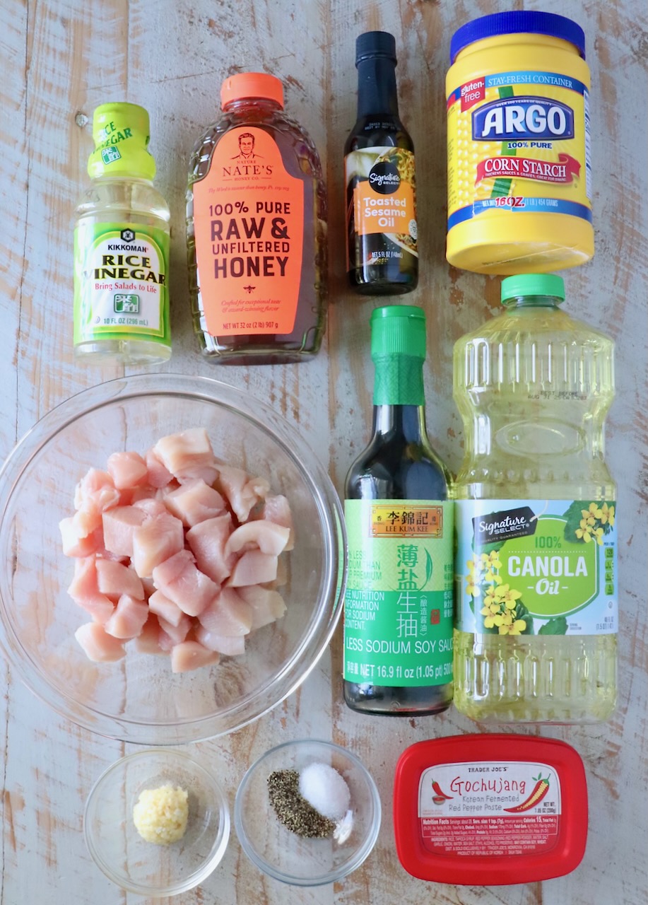 ingredients for gochujang chicken on a white wood board