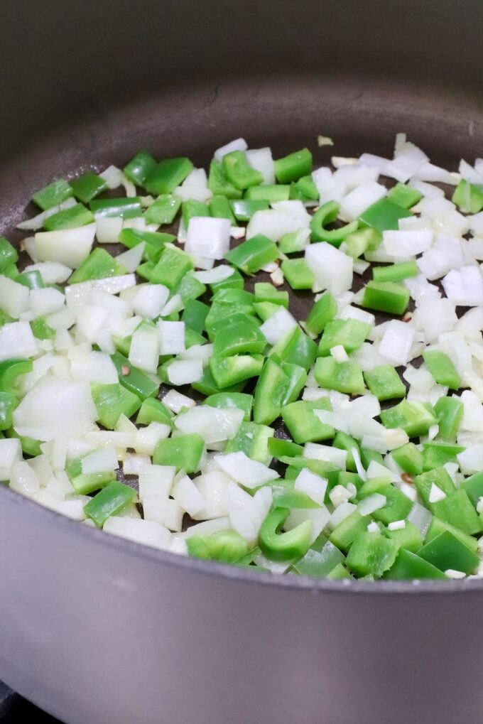 diced onions and green bell peppers in a large pot