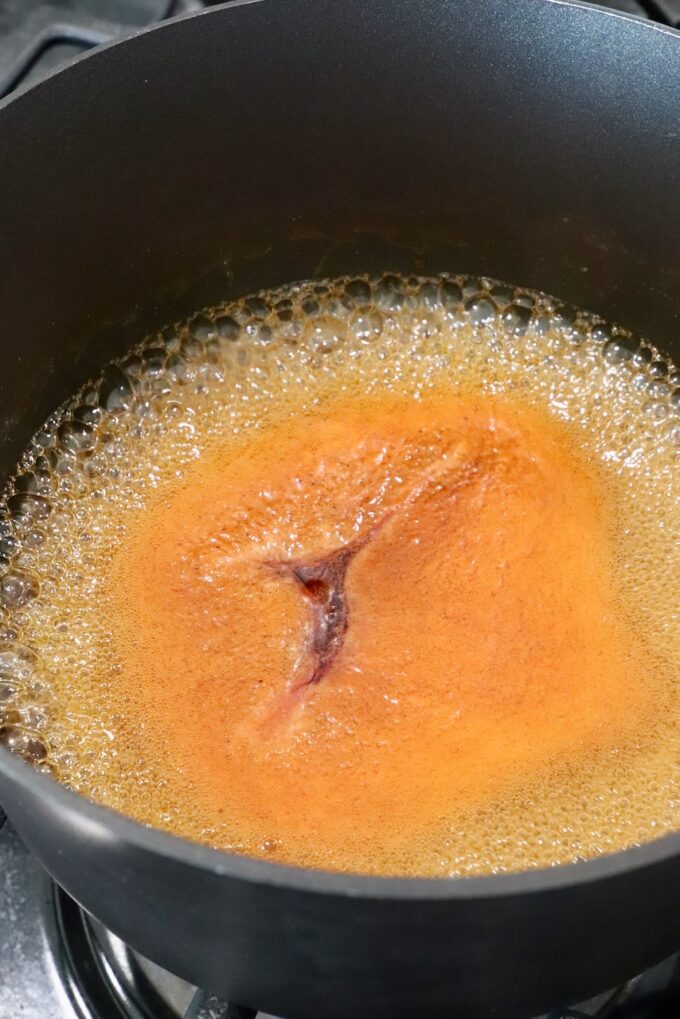 hot honey sauce bubbling in a pot on the stove