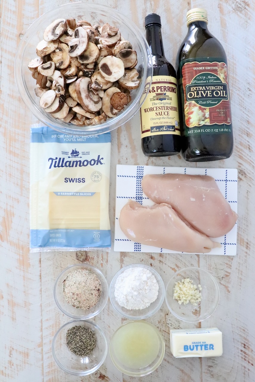 ingredients for mushroom chicken on a white wood board