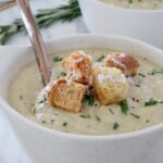 parsnip soup in bowl topped with croutons