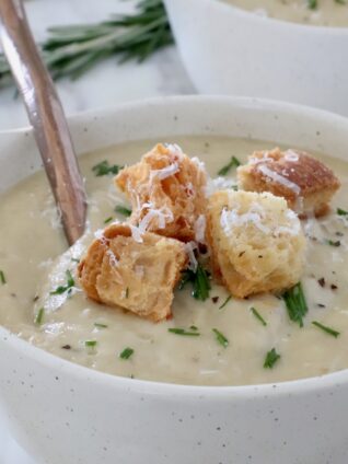 parsnip soup in bowl topped with croutons