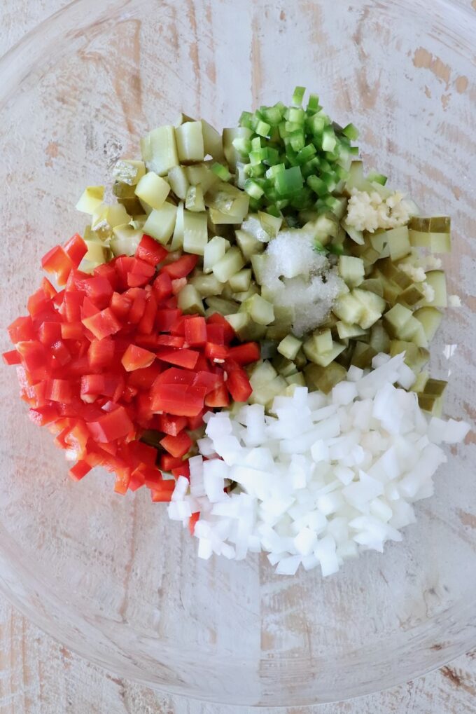 diced pickles, onions and peppers separated in a glass bowl