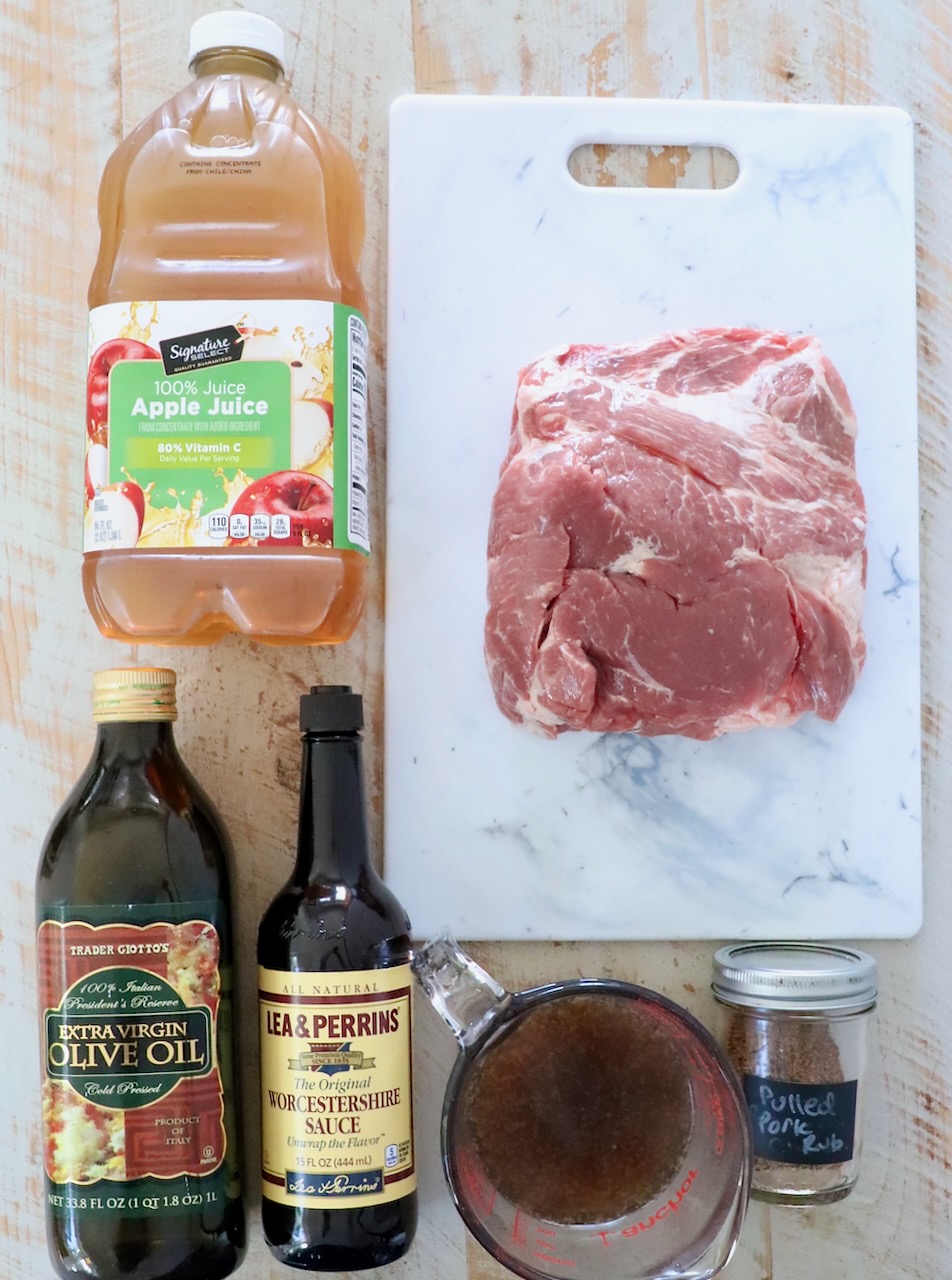 ingredients for pulled pork on a white wood board