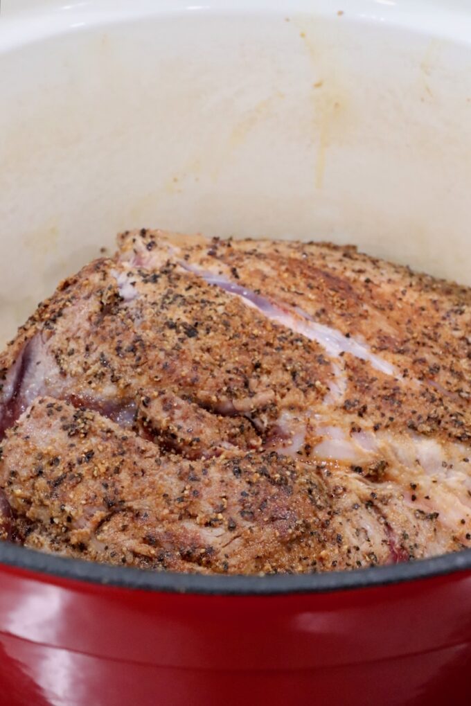 seasoned pork shoulder in a cast iron dutch oven