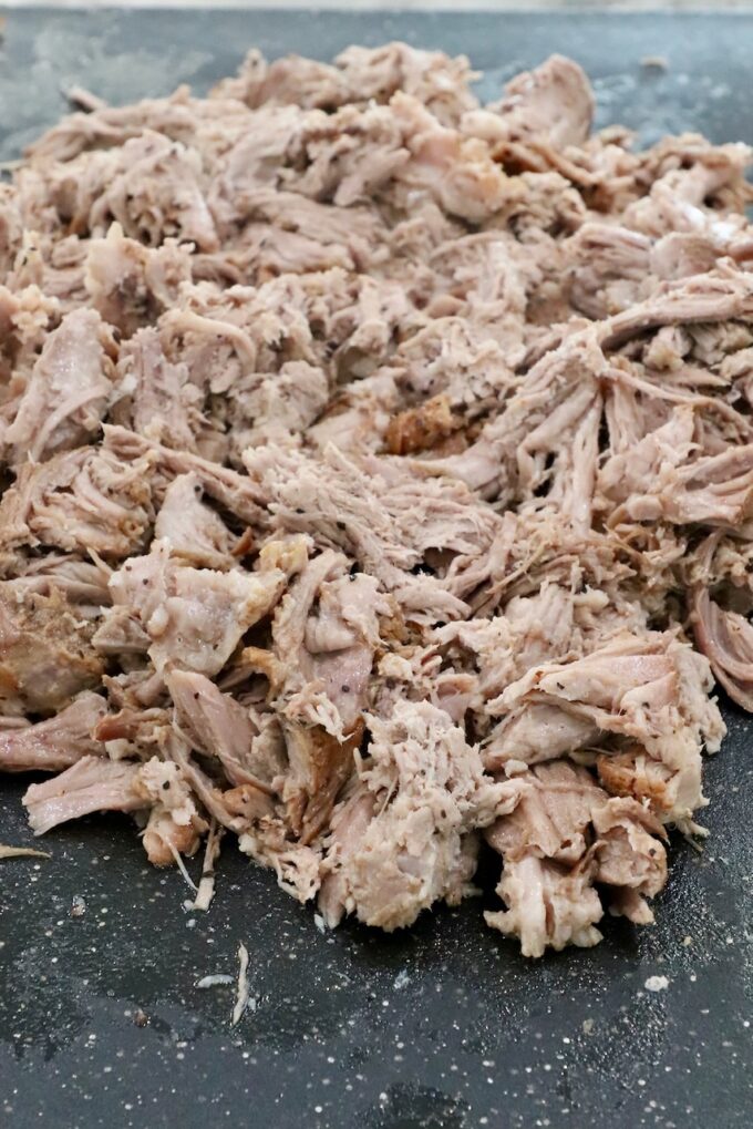 shredded pulled pork on a cutting board