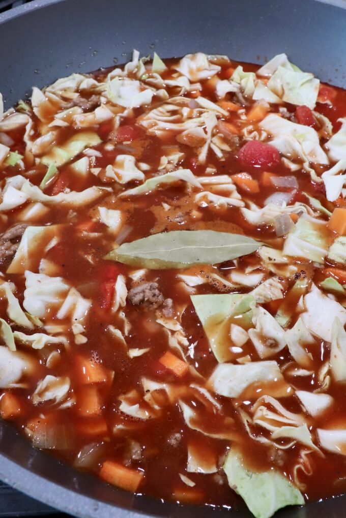 cabbage roll soup ingredients mixed up in a large pot on the stove