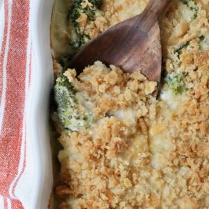 baked casserole with a cracker topping in a baking dish with a serving spoon