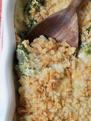 baked casserole with a cracker topping in a baking dish with a serving spoon