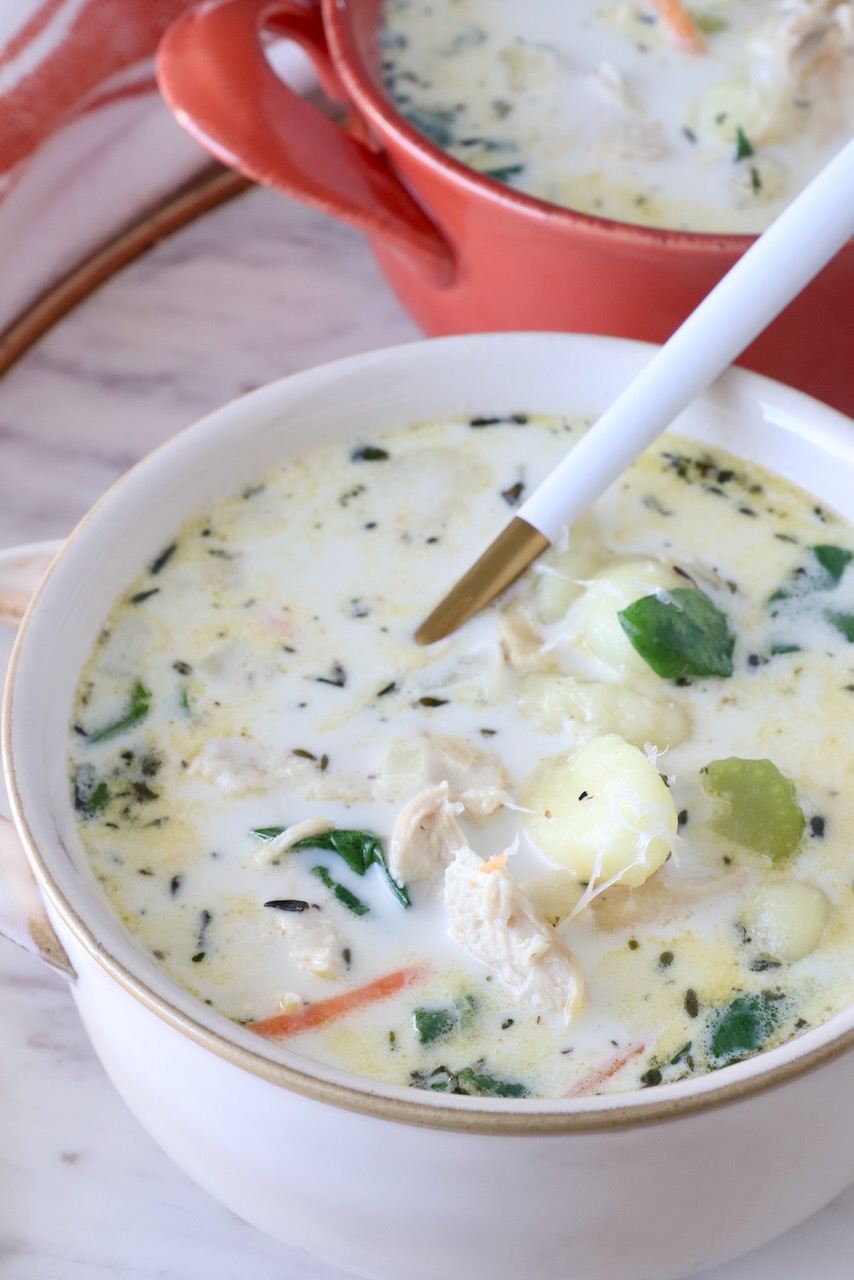 chicken gnocchi soup in bowls with a spoon