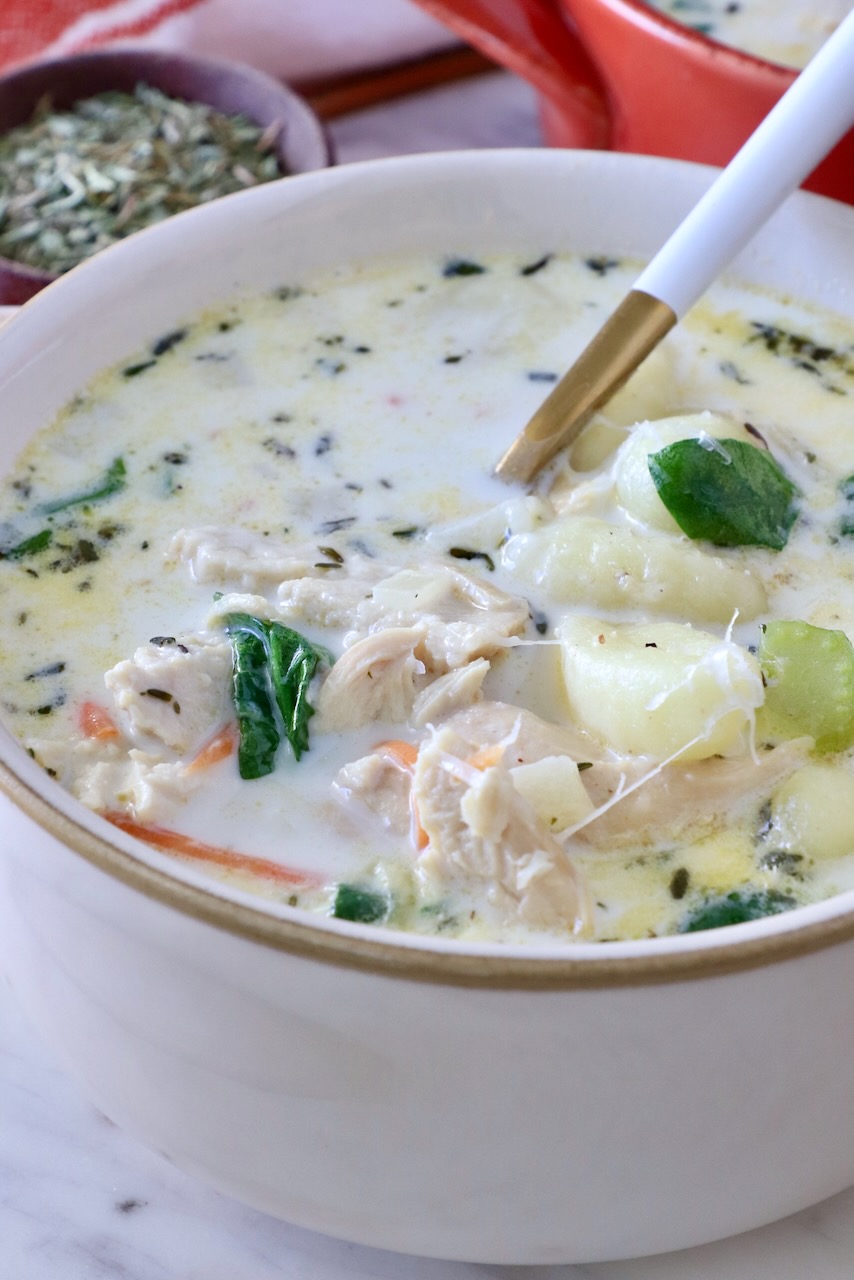 chicken gnocchi soup in a bowl with a spoon