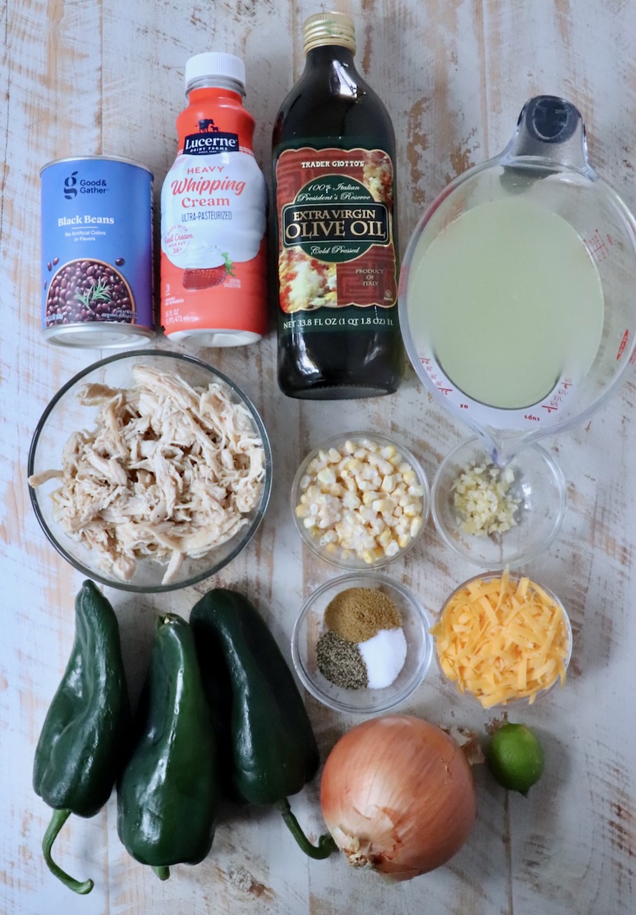 ingredients for chicken poblano soup on a white wood board